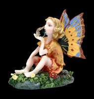 Small Fairy Figurine sitting on a Flowers Meadow