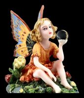 Kleine Elfen Figur sitzt in Blumenwiese