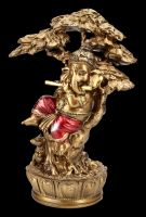 Ganesha Figur musiziert unter Baum